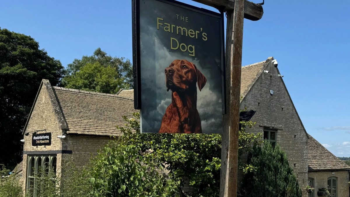 The Farmer's Dog pub sign, with a red Labrador, outside the stone pub