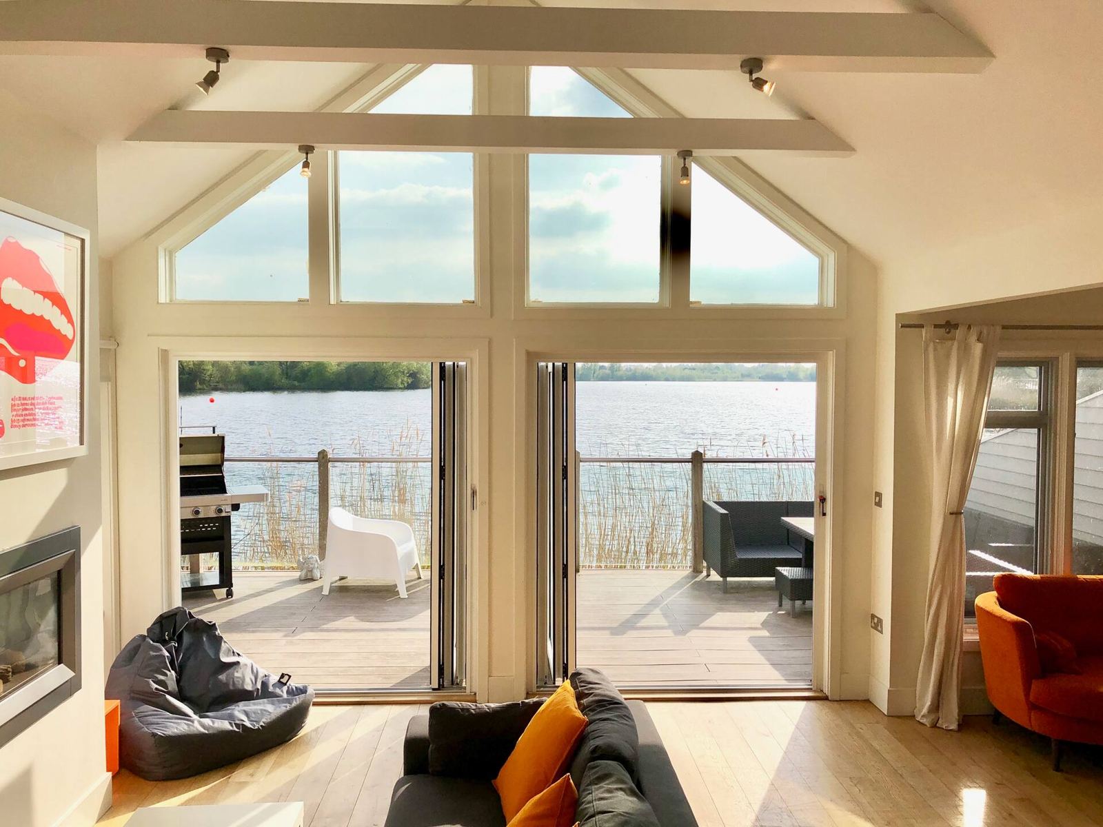 Living room with bi-fold doors open to the lake